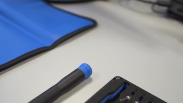 Chave de fenda um pouco preparada para uso em um tapete azul — Vídeo de Stock
