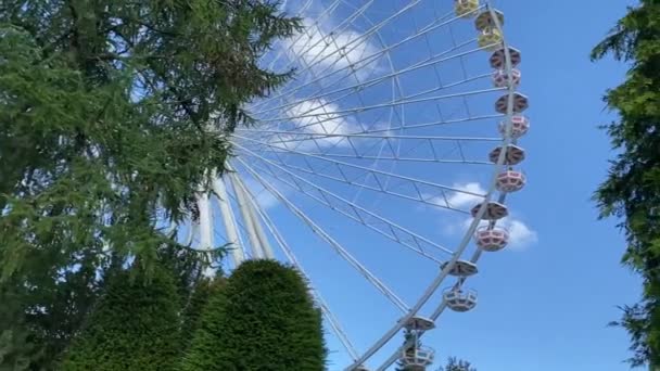 Чертово колесо в парке аттракционов, хорошая погода, голубое небо Лицензионные Стоковые Видеоролики