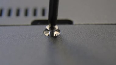 El yapımı bir zanaatkar tornavidayla vidayı sıkar..