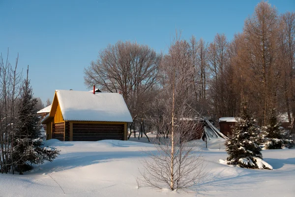 Hus i witer trä med snö på tak — Stockfoto