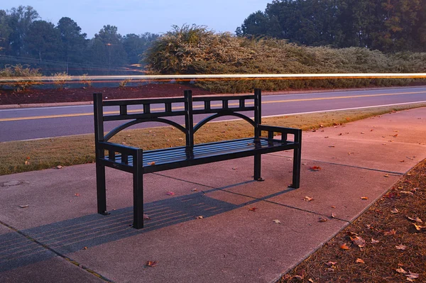 Скамейка возле дороги — стоковое фото