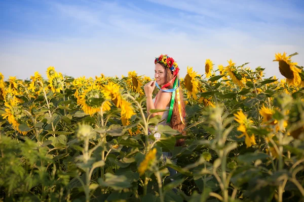Mooie jonge vrouw op zonnebloem field — Stockfoto