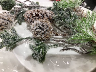 Noel modeli, gri seramik veya kil tabaka üst görünümü yazı veya tasarım için, ladin veya çam dalı ile kaplı ahşap bir kırsal masa üzerinde.