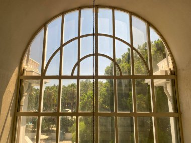 Beyaz tuğla duvarlı ve büyük kemerli yatak odasındaki paletlerin yatağı.