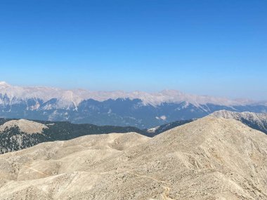 Kemer yakınlarındaki Tahtalı Dağı'nın tepesinden gün batımında Toros Dağı'nın panoramik manzarası, Antalya, Türkiye.