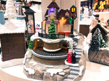 Oyuncak Noel Seramik Minyatür karla kaplı şehir ve insanlar yürüyen modeli ile. Saat Kulesi ile küçük bir festival köy. Retro filtre efekti. Seçici odak, kopya alanı.