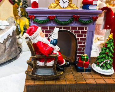 Sevimli Noel Baba renkli Noel ağacı ışıkları ve şömine arka planında.