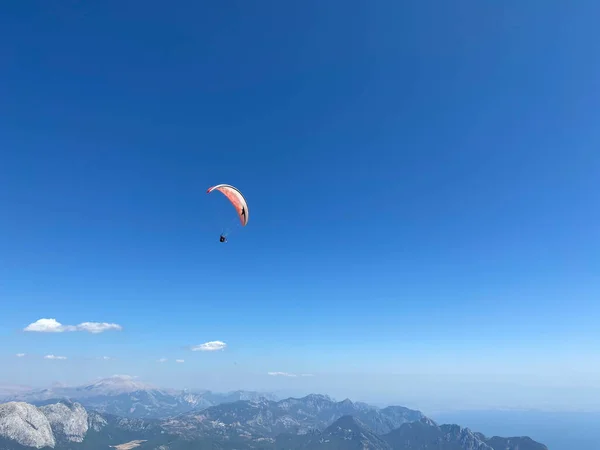 Αλεξιπτωτιστής Πετάει Ψηλά Στον Γαλάζιο Ουρανό Ένα Πολύχρωμο Αλεξίπτωτο — Φωτογραφία Αρχείου