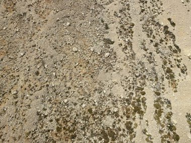 Dağların eteklerinde yağmur vadileri var. Mavi gökyüzü ve kum renkli dağ yamacında.