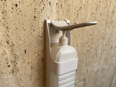 Antiseptik maddenin beyaz fayans duvarında asılı olduğu izole edilmiş şeker kutusunu kapat..