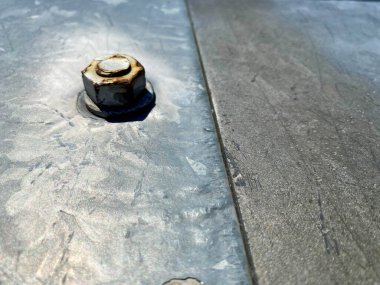 Cıvata ve somun ile metal yüzey gri boyalı.