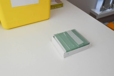 Arşivden ya da laboratuardaki eski kayıtlardan alınan kan testi cam slaytlarını kontrol eden ellerin yakınlaştırılması.