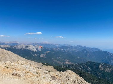 Dağlarda paraşütle atlamak. Paraşütle dağların üzerinden uçma özgürlüğü. Mavi gökyüzünün ardında Paragliding Carpathian Dağları tepeleri manzara. Aktif turizm sporu.