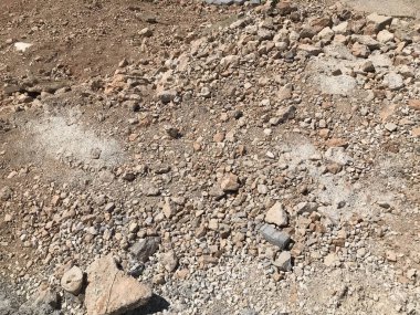 Zeminde küçük taşlar olan sarı parçalı kuru kum. Arka plan. Doku.