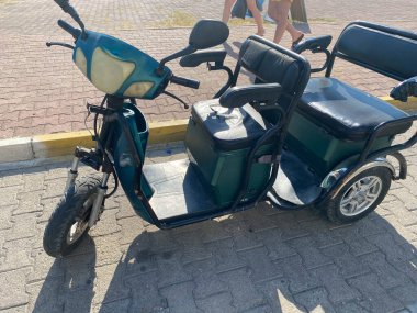 Yolun kenarına park edilmiş üç tekerlekli motosikletler..