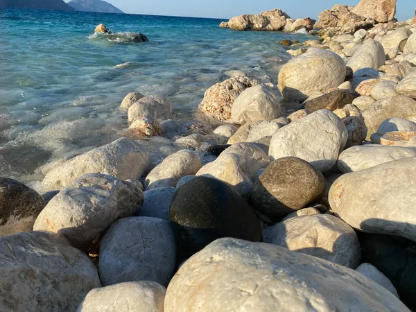 美丽的大型天然圆形卵石和卵石 在海滨或大海中被水冲刷 映衬着群山的背景 — 图库照片