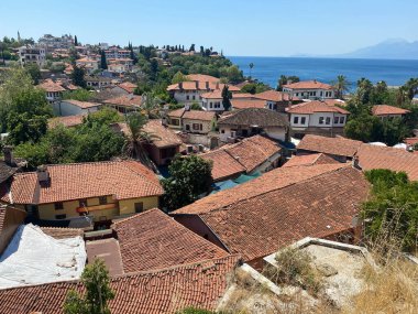 Tarihi evlerin güzel, eski, kırmızı kiremitli çatıları. Deniz kenarındaki eski kasabanın manzarası..