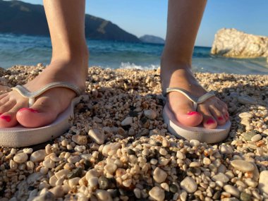 Parmak arası terlik giymiş genç bir kadının güzel ayakları..