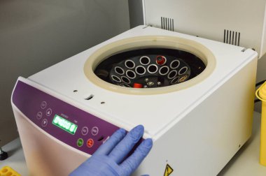 Tıbbi kimyasal araştırma laboratuvarında test tüpleri ve mataralar için güzel yuvarlak santrifüj..