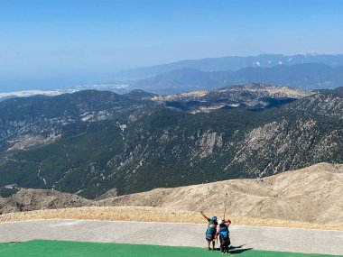 Basejumper elinde bir pilot paraşütü tutuyor, çok aşağıdaki nehrin arka planına doğru yüksek bir uçurumdan uçuruma atlamaya hazırlanıyor..