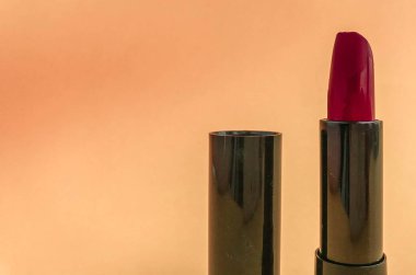 Pembe arka planda siyah bir pakette ruj izi. Parlak kırmızı ruj, retro gölge, nefis güzel dudaklar. Moda ruj tonu.