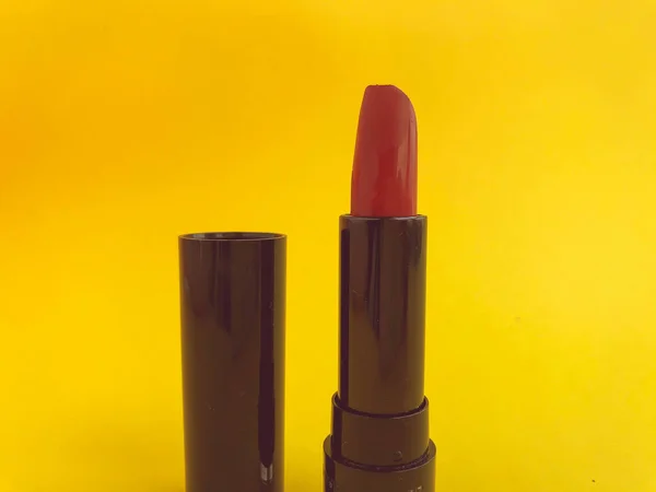 黄色のマットの背景に黒のコンパクトなパッケージに口紅 明るい赤口紅日陰の創造唇の水分補給 スタイリッシュで流行の日陰 — ストック写真