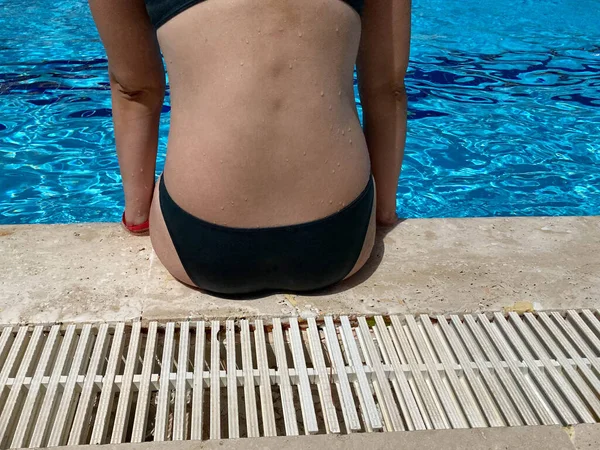 아름다운 수영장 가장자리에 수영복을 뒤에서 바라봅니다 호텔에 휴양지에서 휴가를 보내는 — 스톡 사진