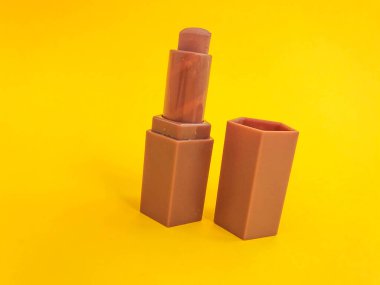 Sarı bir arka planda mat ruj izi. Bej rengi ruj, yumuşak kahverengi renk. Çıplak dudak makyajı, hassas gölge..