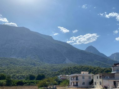 Ceresio Gölü 'nün hemen yanında bahçeli iki dairesi olan modern bir ev. Mavi gökyüzü güneşli. Minimalist ve doğrusal mimari. Yaz boyunca yeşil tepelerin arka planında panoramik manzara.