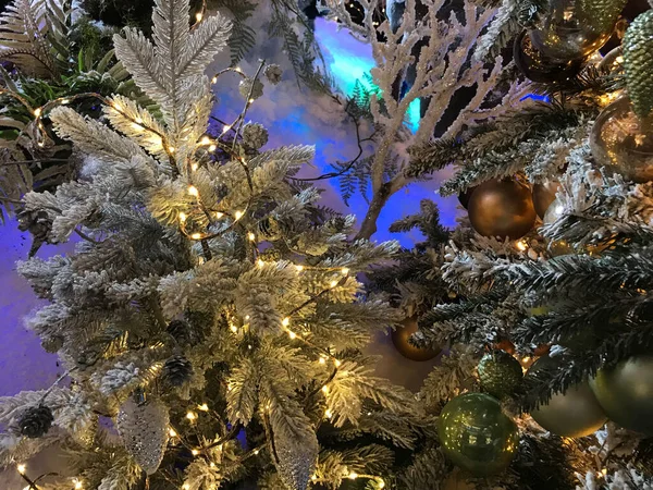 装饰着闪闪发光的花环和绿松冷杉树枝的墙壁的纹理 圣诞节装饰的背景照亮了晚上 — 图库照片