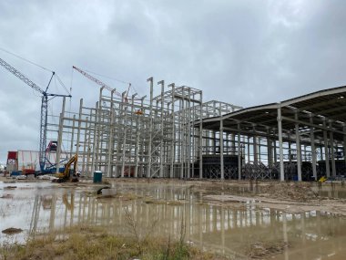 Metal yapıdan Depo İnşaatı. Çelik Yapı Deposu. Işık göstergesi çelik çerçeveli. Kamyon vinci çelik yapıdan depoyu inşa ediyor. İnşaat alanı.