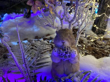 Oyuncak sincap ya da sincap tüylü bir köknar dalında oturuyor. Mutlu Noeller ve Yeni Yıl Kutlama Kartı Tasarımı. Yeni yıl ve Noel kavramı. Şenlikli dekorasyon.