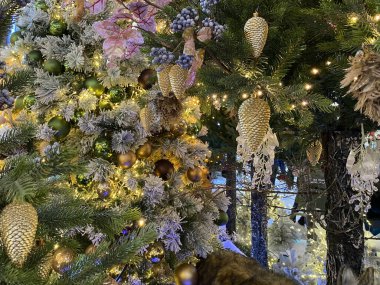 Yapay bir Noel ağacının dallarında parlak kırmızı Noel oyuncakları. Kar topu ve böğürtlen. Çeşitli şenlikli aksesuarlar..