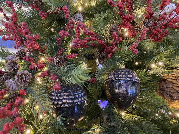 节日树上的圣诞装饰品 许多彩球 彩灯和枝头上的红色浆果都撒满了雪 — 图库照片