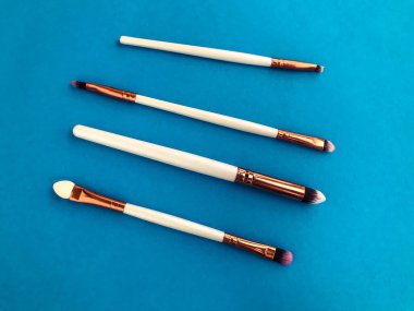 Yüzün derisine kırılgan ve sıvı dokular uygulamak için açık mavi arkaplanda dört fırça. Gölgeler için fırçalar, doğal kıllardan yapılmış göz makyajı..