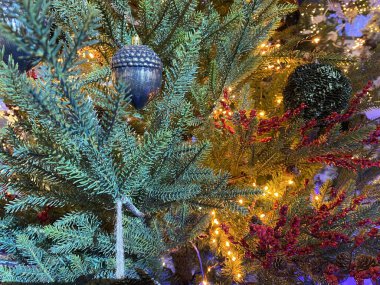 Yeşil ladin dalındaki Noel ağacı oyuncağına yakın plan. Bir Noel arkaplanı.