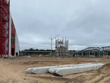 Endüstriyel bir fabrikanın şantiyesinde büyük beton kirişler var..