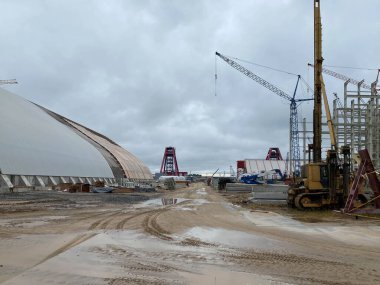 Şehrin altyapısında endüstriyel metal konteynırlar ve vinçler.