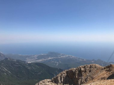 Yüksek bir dağdan ormana ve tropikal bir ülkede tatil köyleri ve deniz manzaralı güzel bir manzara..