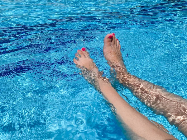 아름다운 여인의 다리가 수영장에서 물장구를 — 스톡 사진