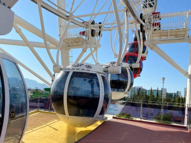 Mavi gökyüzüne karşı büyük kırmızı ve beyaz dönme dolap..