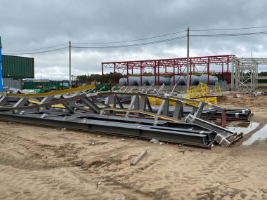 Under construction building including metal roof structure and concrete pillar also scaffold.