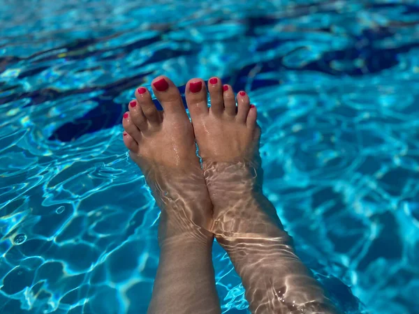 Paar Vrouwenvoeten Met Roze Manicure Blauw Zwembad Achtergrond — Stockfoto