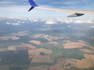 Uçuyor ve seyahat ediyor, günbatımında uçağın penceresinden bakıyor..