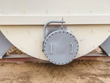 Metal konteynır. İnşaat malzemeleri için derin konteynır. Yüksek hacimli bir tankta beton arıtımı. Çemberli doku. Taşıyıcıyı açmak için kullanışlı kullanıcılar.