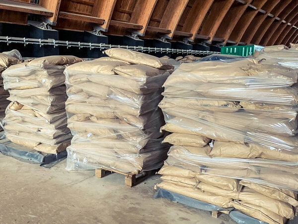 wood warehouse. in the warehouse of fertilizers and building materials. bales at the construction site, sand is poured in transparent bags.