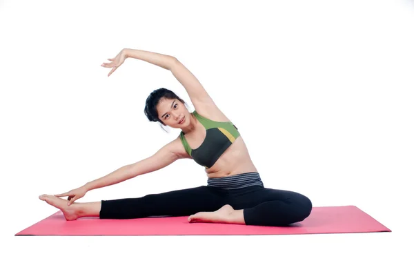 Hermosa mujer haciendo ejercicio en interiores usando alfombra de yoga rosa —  Fotos de Stock