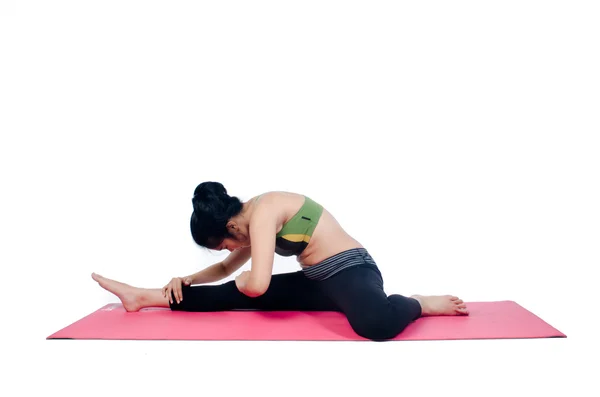 Hermosa mujer haciendo ejercicio en interiores usando alfombra de yoga rosa — Foto de Stock