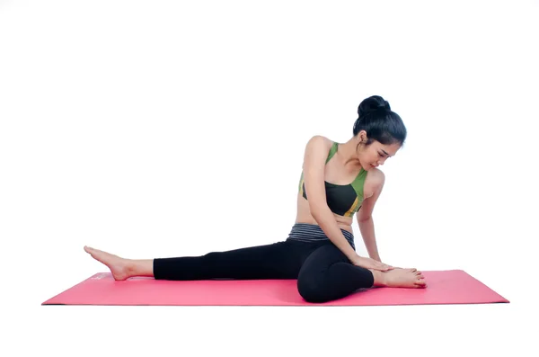 Hermosa mujer haciendo ejercicio en interiores usando alfombra de yoga rosa — Foto de Stock