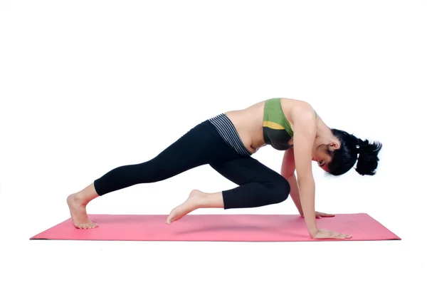 Beautiful woman indoor exercising using pink yoga mat — Stock Photo, Image